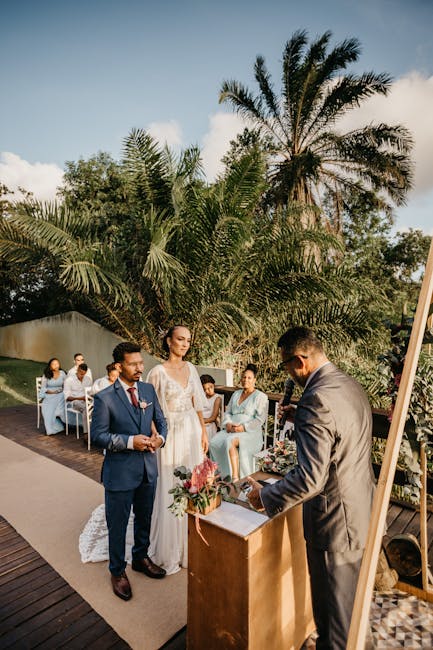 Multiethnic couple on wedding ceremony with unrecognizable officiant and guests